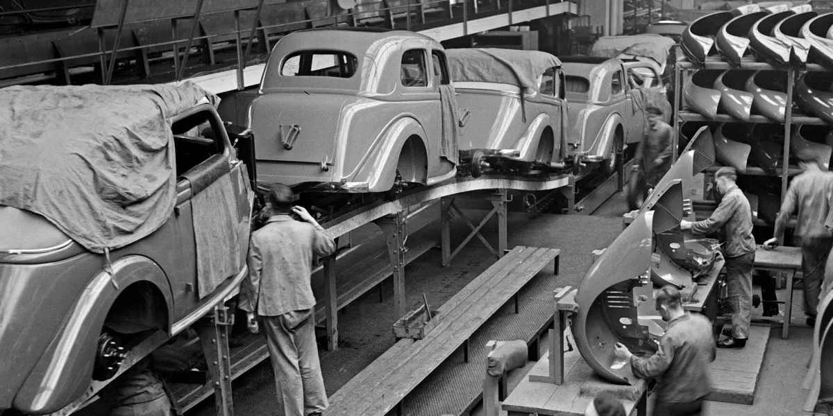 Schwarzweißbild einer Autofabrik. Arbeitsmediz und Arbeitssicherheit waren früher keine Selbstverständlichkeit. © Shutterstock, Vyntage Visuals