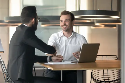 Unternehmer und Arbeitnehmer führen ein erfolgreiches Mitarbeitergespräch. © Shutterstock, fizkes