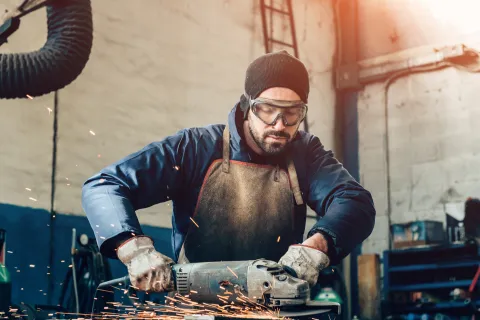 Mitarbeiter arbeitet mit Flex. In Deutschland gibt es mehrere Berufsgenossenschaften, die jeweils für die unterschiedlichen Branchen zuständig sind. © Shutterstock, Riccardo Piccinini