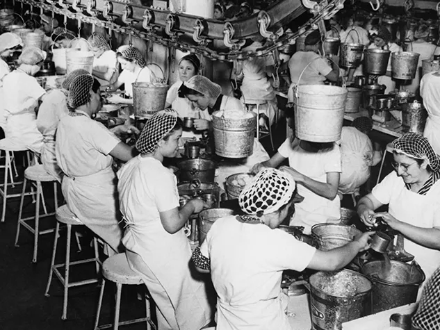 Schwarzweißbild von Frauen in Fabrik. Ob für Frauen, Männer oder Jugendliche: Die Arbeitsbedingungen waren früher besonders hart. © Shutterstock, Everett Collection