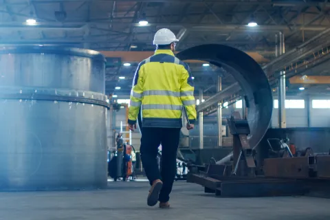 Mitarbeiter trägt Schutzkleidung. Das Arbeitsschutzgesetz bildet die Grundlage für wichtige Schutzmaßnahmen am Arbeitsplatz. © Shutterstock, Gorodenkoff