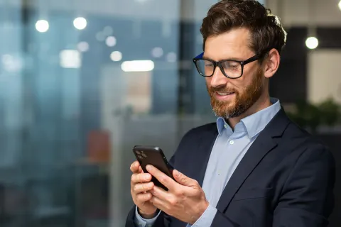 Mann, der sich auf dem Handy über die Änderungen 2025 für Unternehmer informiert. © Adobe Stock, Liubomir