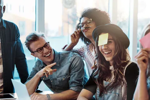 Teamitglieder haben Spaß bei der Arbeit und spielen mit Notizzetteln. © Shutterstock, Ground Picture