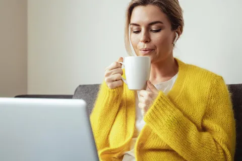 Eine Frau arbeitet aus dem Home-Office und trinkt einen Tee gegen ihren Winterblues. © Envato, BLACKDAY