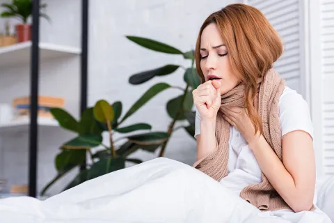 Eine Mitarbeiterin ist arbeitsunfähig und liegt mit einer Erkältung im Bett.