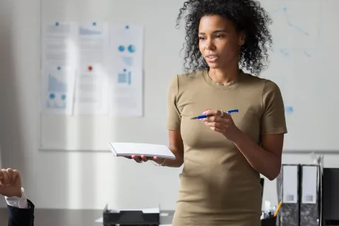 Unternehmerin erklärt Mitarbeitern die DGUV Vorschriften. Arbeitgeber müssen viele Gesetze und Regeln für den Arbeitsschutz beachten. © Shutterstock, fizkes