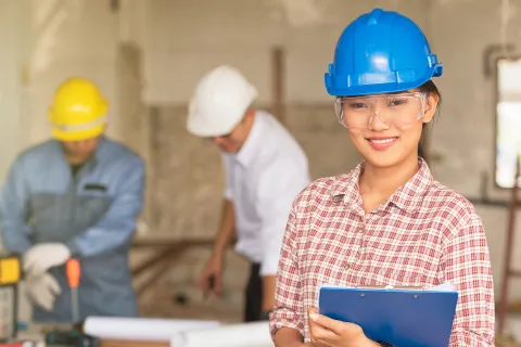 Sicherheit geht vor: Arbeitgeberin mit Schutzhelm prüft die Arbeitssicherheit in ihrem Unternehmen.  © Shutterstock, Pentium5