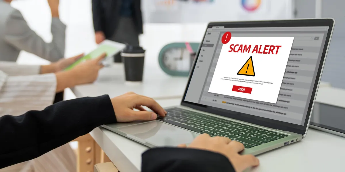 Ein Mitarbeiter wird durch eine Meldung auf seinem Laptop über einen Hackerangriff informiert.