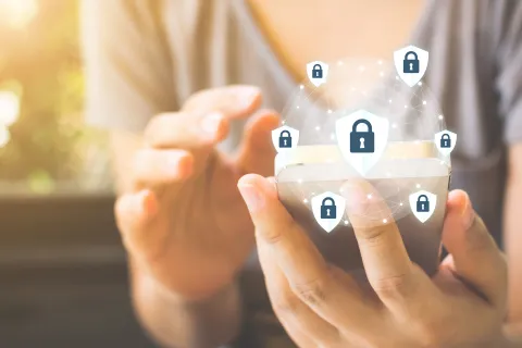 Ein Unternehmer am Smartphone, darüber sind die Schlosssymbole als Sinnbild für die DSGVO zu sehen. © Shutterstock, Monster Ztudio