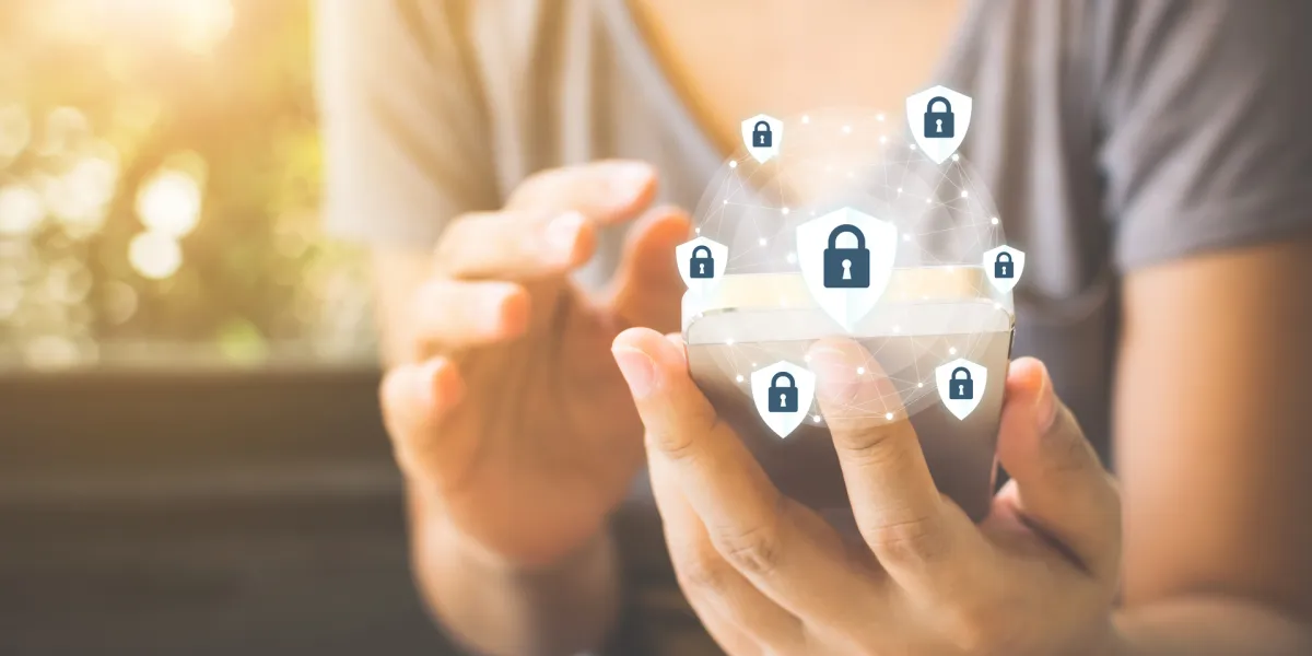 Ein Unternehmer am Smartphone, darüber sind die Schlosssymbole als Sinnbild für die DSGVO zu sehen. © Shutterstock, Monster Ztudio