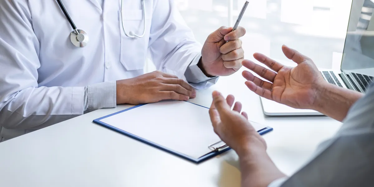 Mitarbeiter spricht mit dem Betriebsarzt. Ein vertrauensvolles Verhältnis ist wichtig. © Shutterstock, SuperOhMo