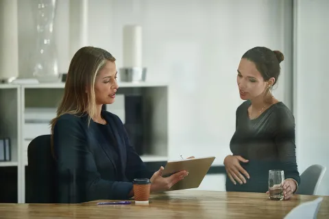 Vorgesetzte bespricht mit einer schwangeren Mitarbeiterin das Mutterschutzgesetz.